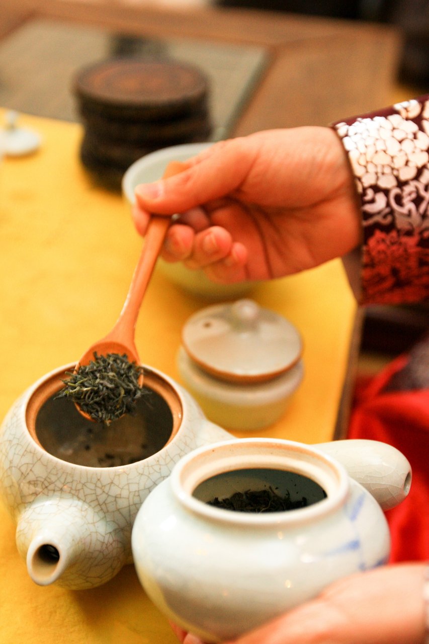 Placing green tea leaves into a Dagwan(teapot)